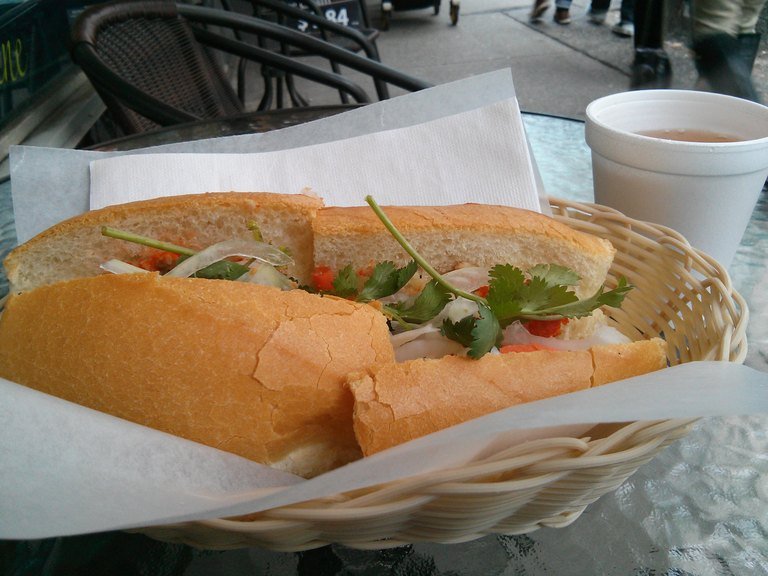 Vietnamese banh mi sandwich with pickled vegetables and cilantro in a basket