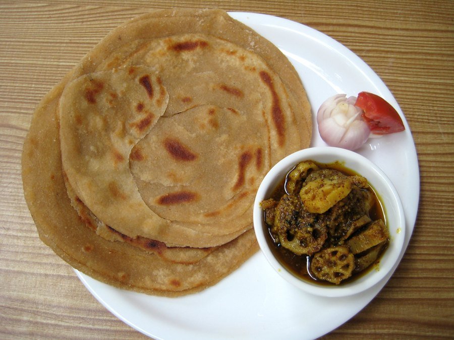 Flaky layered parathas stacked on a plate